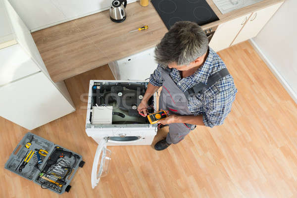 Stock photo: Technician Checking Washing Machine With Digital Multimeter