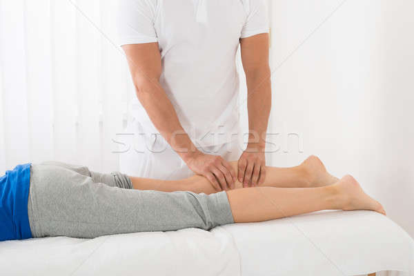 Man Giving Leg Massage To Woman Stock photo © AndreyPopov