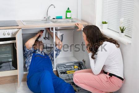 Stock photo: Housemaid Cleaning Oven In Kitchen
