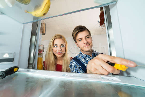 Mulher olhando masculino trabalhador geladeira Foto stock © AndreyPopov