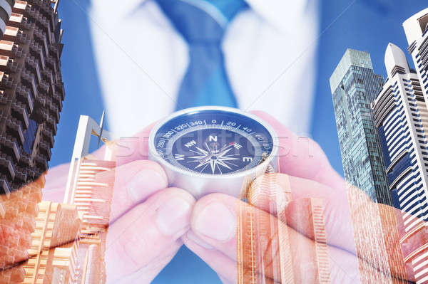 Businessman Holding Navigational Compass Over City Background Stock photo © AndreyPopov