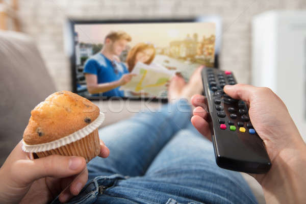Woman Holding Cupcake And Remote Control In Hand Stock photo © AndreyPopov