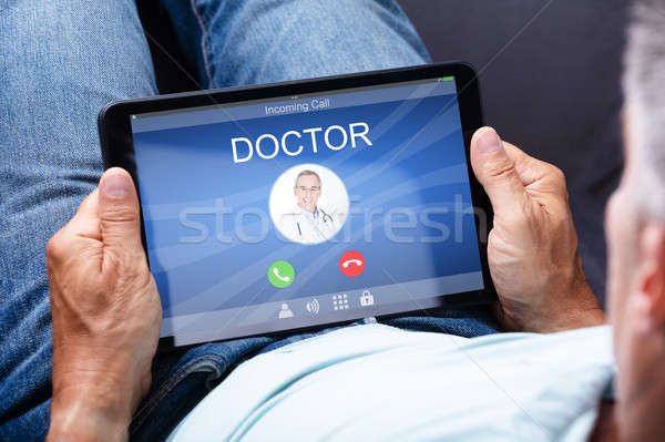 Man Holding Digital Tablet With Doctor's Call On Display Stock photo © AndreyPopov