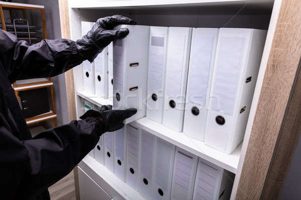 Thief Stealing Folder From Shelf Stock photo © AndreyPopov