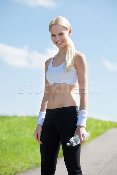 Happy Young Woman Holding Water After Jogging Stock photo © AndreyPopov