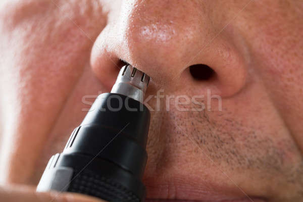 Man Removing Hair From His Nose With Trimmer Stock photo © AndreyPopov