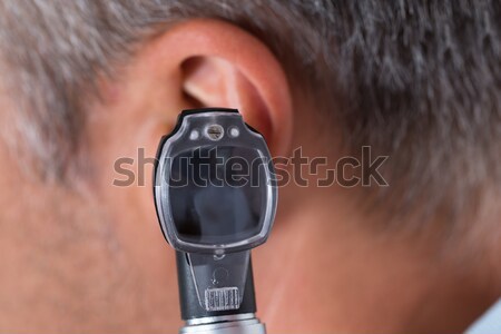 Doctor Checking Ear Of Male Patient Stock photo © AndreyPopov