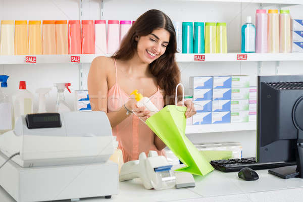 Saleswoman Putting Product Into Bag At Checkout Counter Stock photo © AndreyPopov