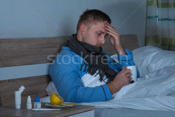 Man Suffering From Headache Sitting On Bed Stock photo © AndreyPopov