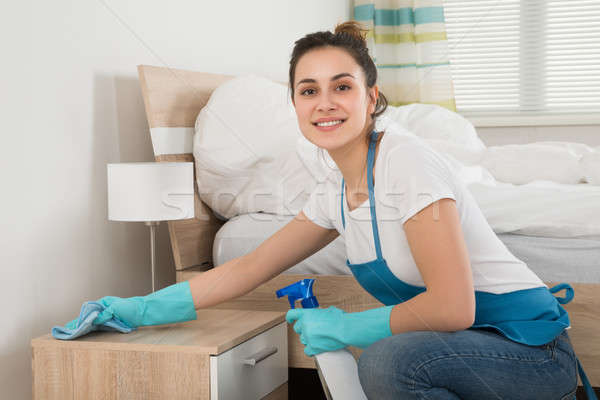 Weiblichen Haushälterin Reinigung Nachttisch glücklich Zimmer Stock foto © AndreyPopov