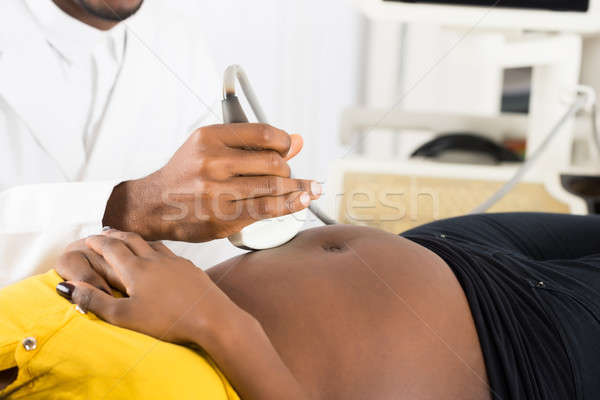 Doctor's Hand Moving Ultrasound On Pregnant Woman's Belly Stock photo © AndreyPopov