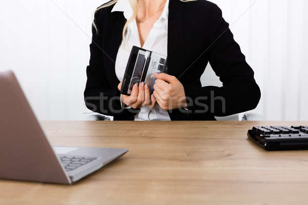Businesswoman Stealing A Calculator Stock photo © AndreyPopov