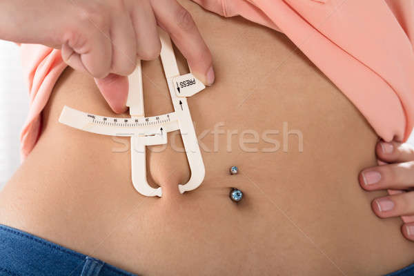 Woman Measuring His Body Fat With Calipers Stock photo © AndreyPopov