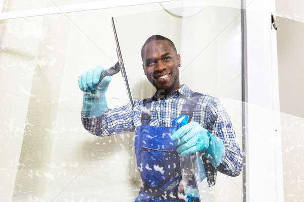 Male Worker Cleaning Glass With Squeegee Stock photo © AndreyPopov