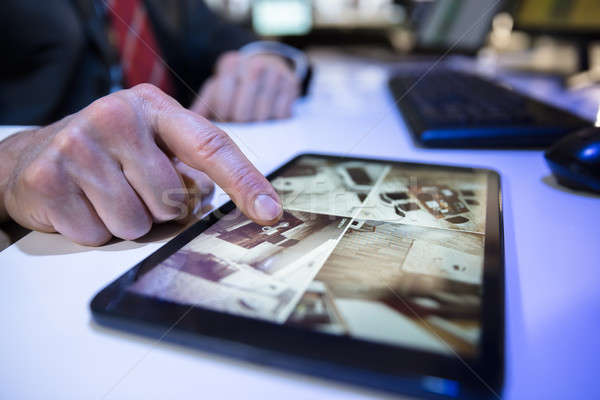 Businessman Looking At CCTV Camera Footage On Digital Tablet Stock photo © AndreyPopov
