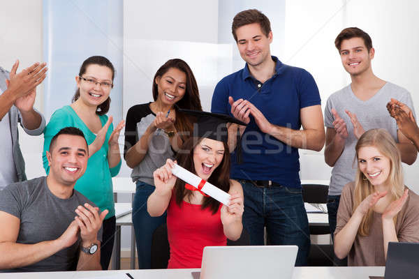 Students Clapping For Classmate Holding Degree Stock photo © AndreyPopov