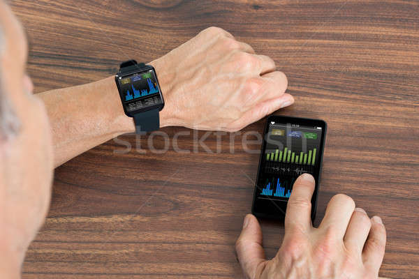 Man With Smartwatch And Cellphone Showing Heartbeat Rate Stock photo © AndreyPopov