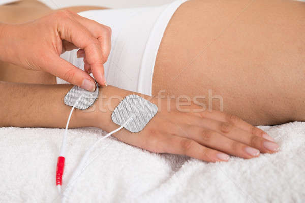 Therapist Placing Electrodes On Woman's Hand Stock photo © AndreyPopov