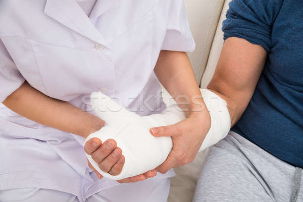 Female Doctor Holding Fractured Hand Of A Patient Stock photo © AndreyPopov