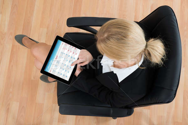 Femme d'affaires regarder calendrier numérique comprimé [[stock_photo]] © AndreyPopov