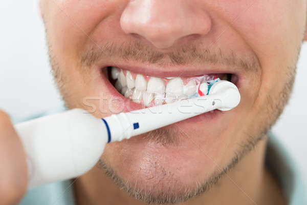 Man Teeth With Electric Toothbrush Stock photo © AndreyPopov