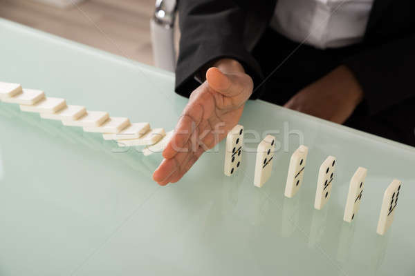 Businesswoman Stopping Dominoes From Falling Stock photo © AndreyPopov