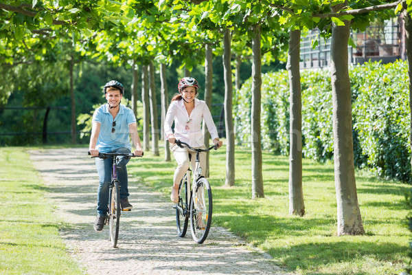 Smiling Couple Riding On Bicycles In The Park Stock photo © AndreyPopov