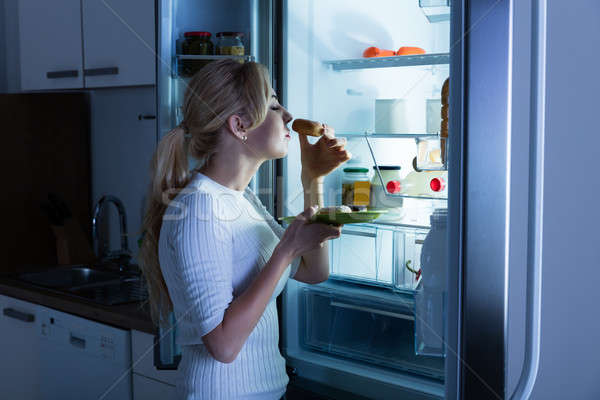 Nő eszik édes étel hűtőszekrény fiatal boldog Stock fotó © AndreyPopov