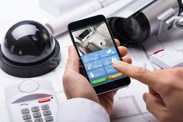 Person Hand Using Home Security System On Mobilephone Stock photo © AndreyPopov