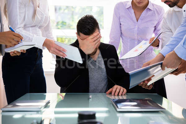 Stressed Businessman Surrounded By His Colleagues Stock photo © AndreyPopov