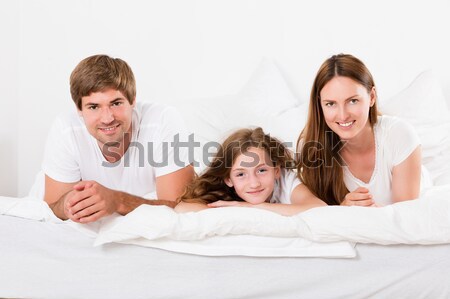 Happy Family With Two Children Lying Heaped On Bed Stock photo © AndreyPopov