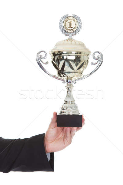 Hand of a businessman displaying a large silver trophy cup Stock photo © AndreyPopov