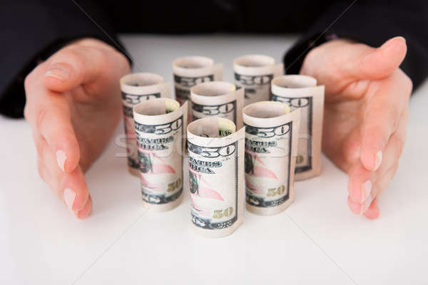 Businesswoman Shielding Rolled Dollar Bills Stock photo © AndreyPopov