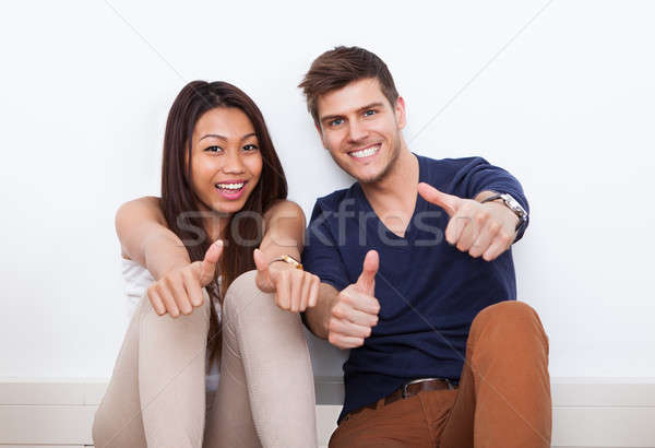 Couple Gesturing Thumbs Up At Home Stock photo © AndreyPopov