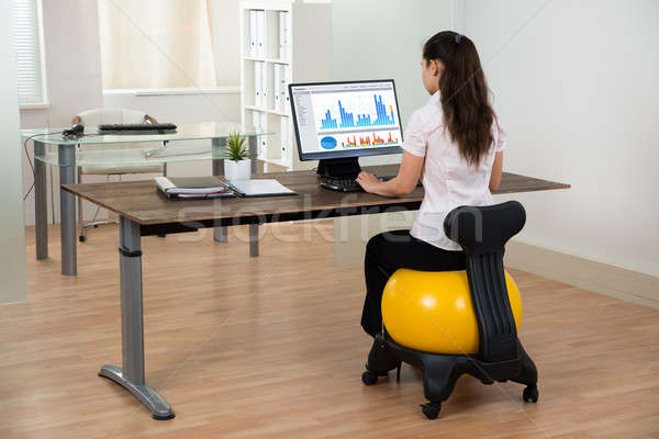 Businesswoman Sitting On Fitness Ball In Office Stock photo © AndreyPopov