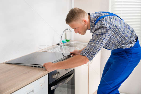 Repairman Installing Induction Cooker Stock photo © AndreyPopov