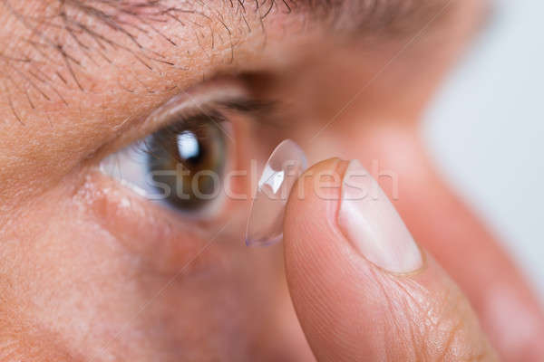 Closeup Of Man Putting Contact Lens In Eye Stock photo © AndreyPopov