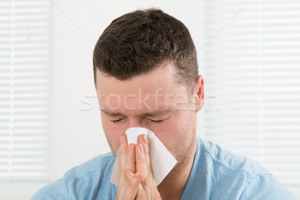Man With Cold Blowing His Nose At Home Stock photo © AndreyPopov