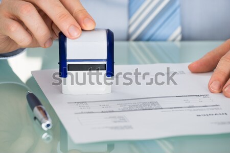 Person's Hand Pressing Stamper On Document Stock photo © AndreyPopov