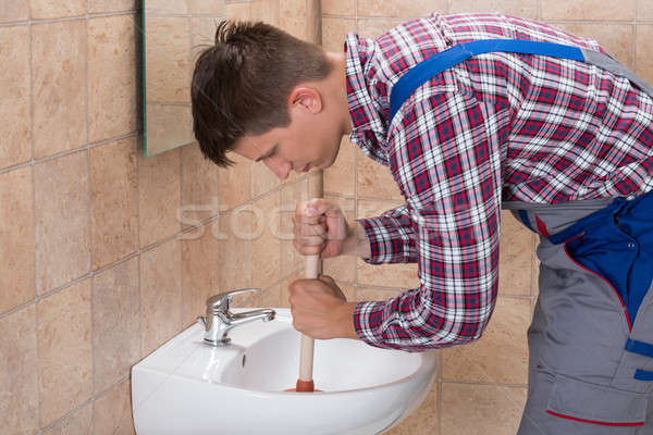 Plumber Using Plunger In Bathroom Sink Stock photo © AndreyPopov