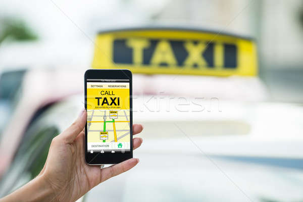 Female's Hand Holding Mobile Phone Booking Taxi Stock photo © AndreyPopov