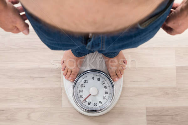 Person Standing On Weighing Scale Stock photo © AndreyPopov