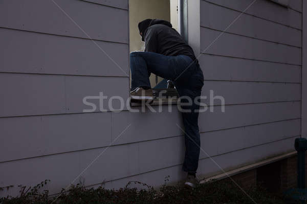 Burglar Entering House Through Window Stock photo © AndreyPopov