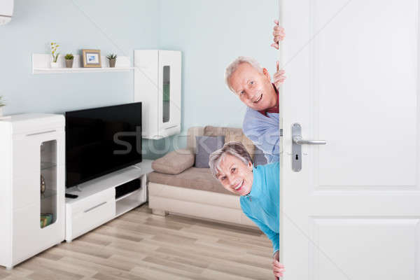 Senior Couple Peeking From Door Stock photo © AndreyPopov