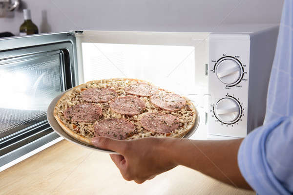 Pessoa salame pizza microonda forno Foto stock © AndreyPopov