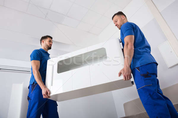 Two Movers Holding Furniture In Living Room Stock photo © AndreyPopov