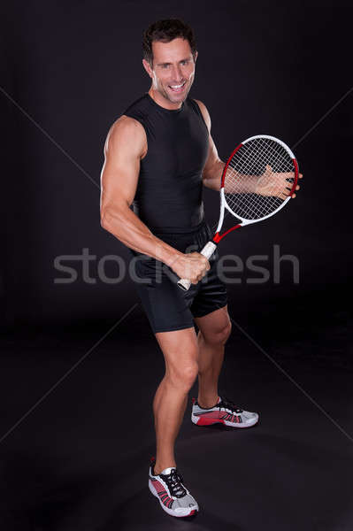 [[stock_photo]]: Jeune · homme · raquette · de · tennis · isolé · noir · sourire