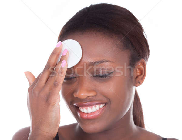 Happy African American woman applying compact Stock photo © AndreyPopov