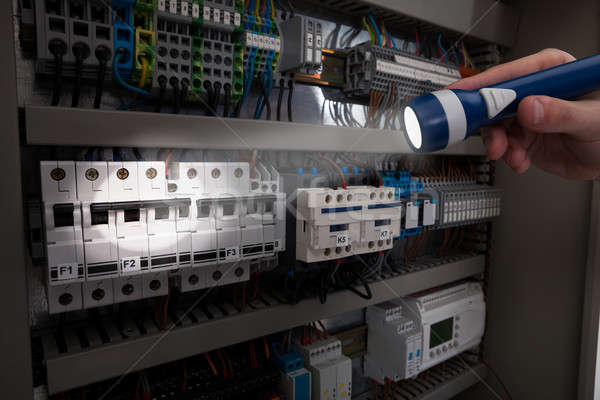 Technician Analyzing Fusebox With Flashlight Stock photo © AndreyPopov