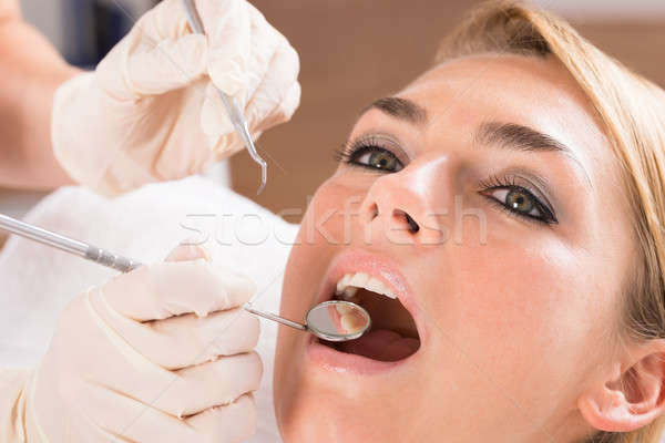 Dentist's Hands Examining Female Patient's Teeth Stock photo © AndreyPopov